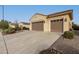 Tan two-story house with a three-car garage and landscaped yard at 20359 N 262Nd Dr, Buckeye, AZ 85396