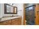 Bathroom with granite vanity, wood cabinets, and a tiled shower at 211 E Desert Wind Dr, Phoenix, AZ 85048