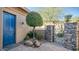 A blue door and lush greenery create a welcoming entry courtyard at 211 E Desert Wind Dr, Phoenix, AZ 85048