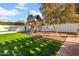 Large backyard with grassy lawn, playset, and brick patio at 2130 E San Juan Ave, Phoenix, AZ 85016