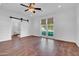 Main bedroom with hardwood floors, barn door, and access to ensuite bathroom at 2130 E San Juan Ave, Phoenix, AZ 85016