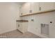 Laundry room with white cabinets and patterned tile floor at 21411 W Meadowbrook Ave, Buckeye, AZ 85396