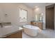 Elegant bathroom with soaking tub, walk-in shower, and gray countertops at 21418 W Meadowbrook Ave, Buckeye, AZ 85396