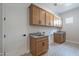 Laundry room with wood cabinets and patterned tile floor at 21418 W Meadowbrook Ave, Buckeye, AZ 85396