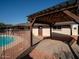 Home features a sparkling pool and relaxing pergola at 2215 E Des Moines Cir, Mesa, AZ 85213