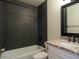 Updated bathroom with dark tile and granite vanity at 2215 E Des Moines Cir, Mesa, AZ 85213