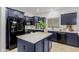 Modern kitchen with dark blue cabinets, stainless steel appliances, and an island at 2528 W Brookhart Way, Phoenix, AZ 85085