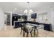 Modern kitchen with dark blue cabinetry, an island, and glass-top dining table at 2528 W Brookhart Way, Phoenix, AZ 85085