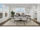 Bright dining room with large windows, wooden table, and light gray chairs at 2693 S 357Th Dr, Tonopah, AZ 85354