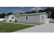 Gray manufactured home with white accents, landscaping, and driveway at 2693 S 357Th Dr, Tonopah, AZ 85354