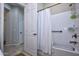 Bathroom with shower/tub combo, grab bars, and white curtains at 27028 W Oraibi Dr, Buckeye, AZ 85396