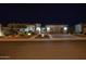 Night view of single-story home with landscape lighting and two-car garage at 27028 W Oraibi Dr, Buckeye, AZ 85396