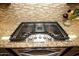 Stainless steel gas cooktop with five burners, situated on a granite countertop at 27028 W Oraibi Dr, Buckeye, AZ 85396