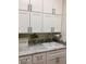 Bright laundry room with white cabinets and a utility sink at 27028 W Oraibi Dr, Buckeye, AZ 85396