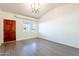 Living room with wood-look floors, a large window, and a brown door at 2929 E Broadway Rd # 13, Mesa, AZ 85204