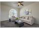 Bright living room features a ceiling fan, large arched window, and comfortable neutral-toned seating arrangement at 2930 N 154Th Dr, Goodyear, AZ 85395