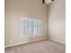 Bedroom with neutral walls and carpet, large window with plantation shutters, and ceiling fan at 3106 E Hiddenview Dr, Phoenix, AZ 85048