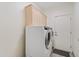 Bright laundry room featuring a front load washer and dryer set and upper cabinets for storage at 3106 E Hiddenview Dr, Phoenix, AZ 85048