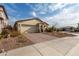 Single-story home with a beige exterior, brick driveway, and desert landscaping at 31817 N 124Th Dr, Peoria, AZ 85383