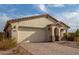 Single-story home with a beige exterior, brick driveway, and desert landscaping at 31817 N 124Th Dr, Peoria, AZ 85383