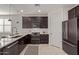 Modern kitchen with dark cabinetry, stainless steel appliances, and a large island at 31817 N 124Th Dr, Peoria, AZ 85383