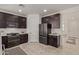 Modern kitchen with dark cabinetry, stainless steel appliances, and tile flooring at 31817 N 124Th Dr, Peoria, AZ 85383