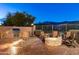 Landscaped backyard with built-in BBQ and fire pit at dusk at 4202 S Cordia Ct, Gold Canyon, AZ 85118