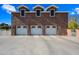 Triple-car garage with brick exterior and white doors at 424 E Lehi Rd, Mesa, AZ 85203