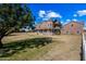 Brick house with a large yard, a white fence, and a tree at 424 E Lehi Rd, Mesa, AZ 85203