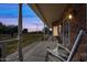 Evening view of a home's porch with rocking chairs and outdoor lighting at 424 E Lehi Rd, Mesa, AZ 85203