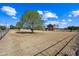 Large grassy yard with mature trees, a split rail fence, and a home in the background at 424 E Lehi Rd, Mesa, AZ 85203