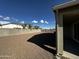 Backyard view showing gravel, block wall, and partial covered patio at 44478 W Palo Abeto Dr, Maricopa, AZ 85138