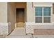 Front entry with a brown door and white brick trim at 44478 W Palo Abeto Dr, Maricopa, AZ 85138