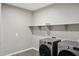 Spacious laundry room, featuring built-in shelving and a modern washer and dryer at 44478 W Palo Abeto Dr, Maricopa, AZ 85138