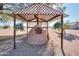 Rustic outdoor brick pizza oven with shaded seating area at 52615 W Esch Trl, Maricopa, AZ 85139