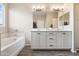 Spa-like bathroom with double sinks, a soaking tub, and wood-look floors at 5758 W Kowalsky Ln, Laveen, AZ 85339