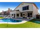 Beautiful backyard featuring a sparkling blue swimming pool, lush green lawn, and covered patio at 6270 W Rose Garden Ln, Glendale, AZ 85308