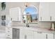 Clean kitchen design with white cabinets, a farmhouse sink, and marble countertops at 6270 W Rose Garden Ln, Glendale, AZ 85308