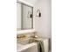 Elegant bathroom featuring marble countertop, stylish faucet, and decorative mirror with sconce lighting at 6737 E Exeter Blvd, Scottsdale, AZ 85251