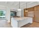 Modern kitchen with large marble island, light wood cabinets, and pendant lighting at 6737 E Exeter Blvd, Scottsdale, AZ 85251