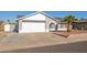 Single-story house with gray exterior, white garage door, and a palm tree in the front yard at 7210 W Pasadena Ave, Glendale, AZ 85303