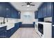 Spacious laundry room with navy blue cabinets and a farmhouse sink at 7480 E Sweetwater Ave, Scottsdale, AZ 85260