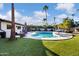 Inviting kidney-shaped pool with surrounding patio and lush landscaping at 7480 E Sweetwater Ave, Scottsdale, AZ 85260