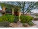 Front view of a two-story home with stone pathway, lush landscaping, and a balcony at 7846 E Mackenzie Dr, Scottsdale, AZ 85251