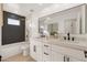 Modern bathroom with double vanity, dark tile, and a soaking tub at 8134 E Rita Dr, Scottsdale, AZ 85255