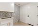 Laundry room with sink, white cabinets, and patterned tile at 8134 E Rita Dr, Scottsdale, AZ 85255