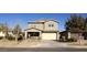 Two-story house with tan siding, attached garage, and landscaping at 9750 E Radioactive Dr, Mesa, AZ 85212