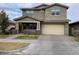 Two-story house with beige exterior, attached garage, and landscaping at 9750 E Radioactive Dr, Mesa, AZ 85212