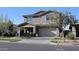 Inviting two-story home with a covered entrance, complemented by mature trees and manicured landscaping at 9750 E Radioactive Dr, Mesa, AZ 85212