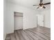 Well-lit bedroom, featuring wood-look floors and a closet at 9821 E University Dr, Mesa, AZ 85207